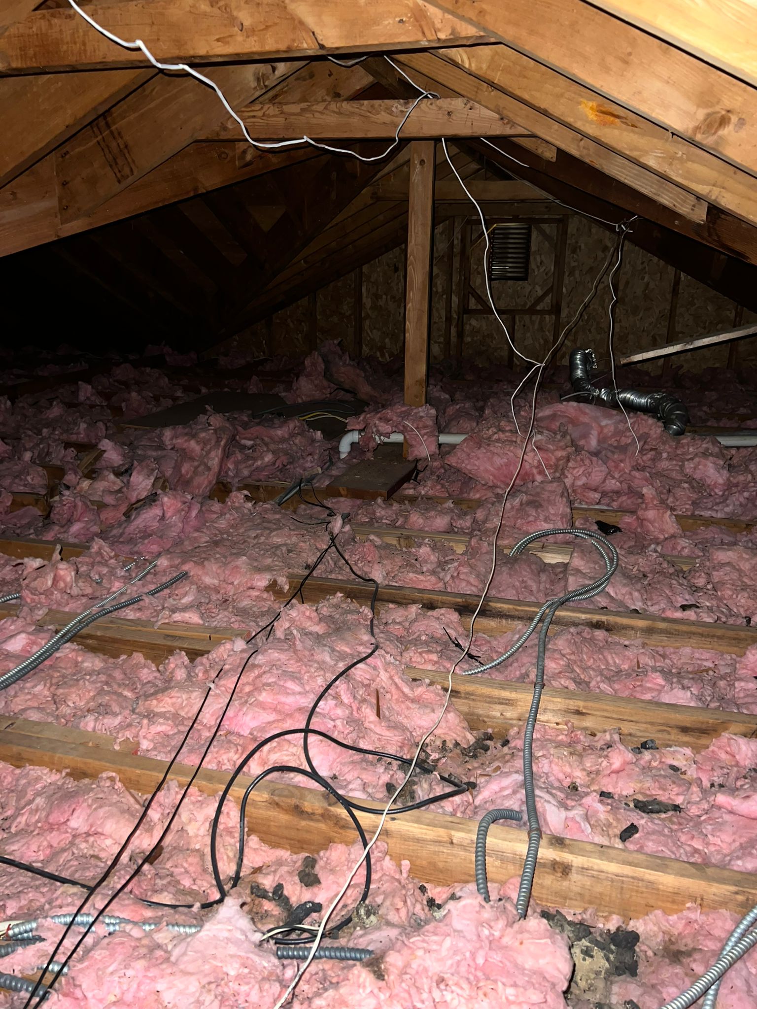 Old damaged insulation in attic before professional removal