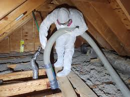 Insulation removal crew extracting old material from attic