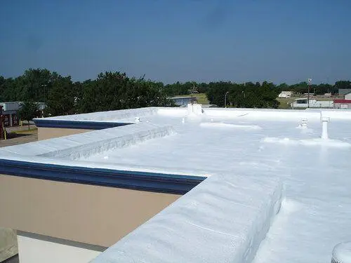 Completed white spray foam roof coating on commercial flat roof
